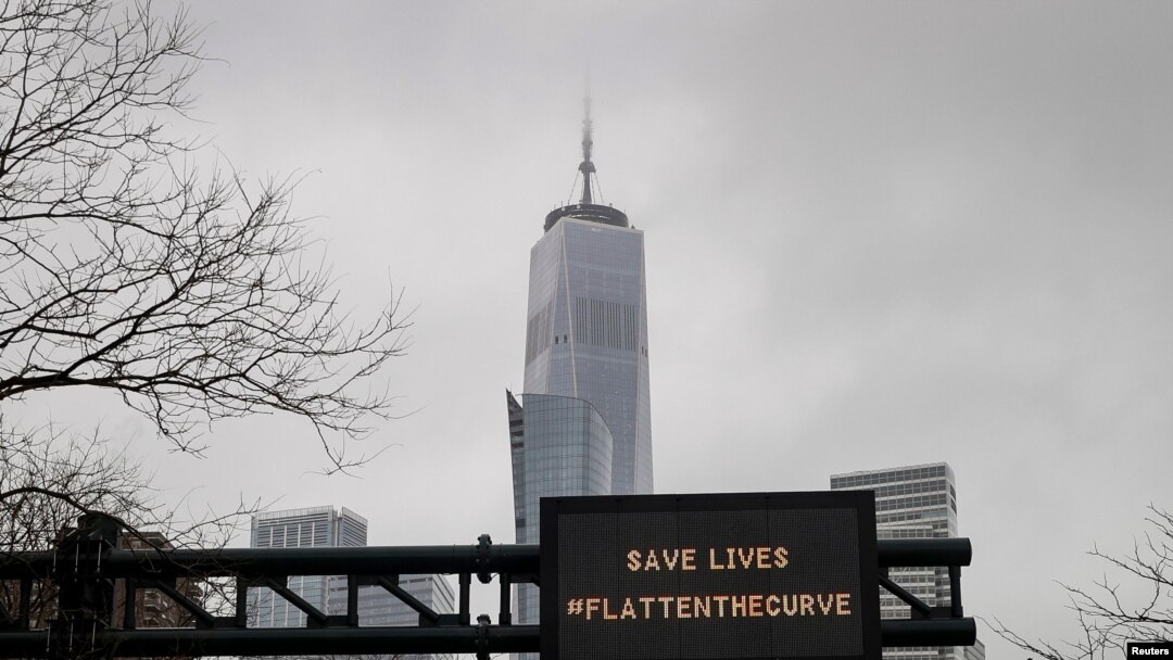 One World Trade is seen behind a sign that flashes an emergency alert, as the coronavirus disease (COVID-19) outbreak continues in New York City, New York.