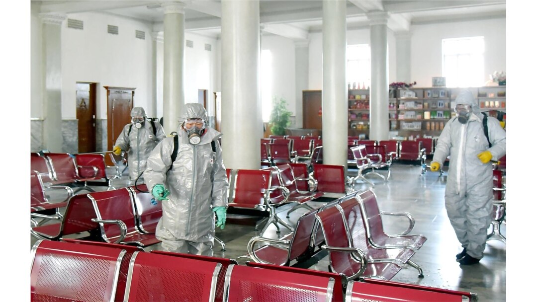 This undated picture released from North Korea's official Korean Central News Agency (KCNA) on February 15, 2020 shows people in protective suits spraying disinfectant at an undisclosed location in North Korea, amid concerns of the COVID-19.