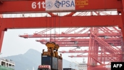 2021年9月7日，一台起重機在中國江蘇省連雲港市的港口將集裝箱裝載到卡車上。 （法新社照片）