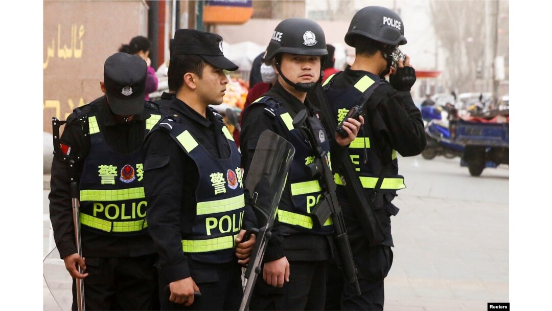 FILE - Armed police keep watch in a street in Kashgar, Xinjiang Uighur Autonomous Region, China, March 24, 2017.
