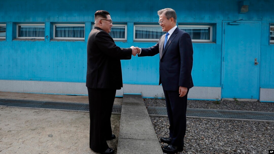 문재인 한국 대통령과 김정은 븍힌 국무위원장이 이 군사분계선에서 처음 만나 악수를 하고 있다. 
