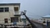An electrical pole felled by Hurricane Elsa leans on the edge of a residential balcony, in Cedars, St. Vincent, July 2, 2021.