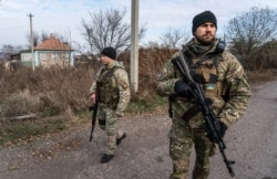 Ukrainian policemen patrol a street near the new line of contact in Katerynivka, Luhansk region, eastern Ukraine, Nov. 2, 2019.
