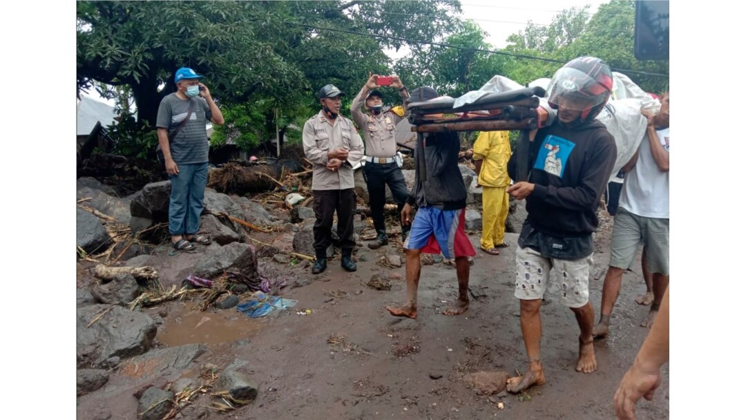 People carry a man injured during a flood in Ile Ape, on Lembata Island, East Nusa Tenggara province, Indonesia, April 4, 2021.