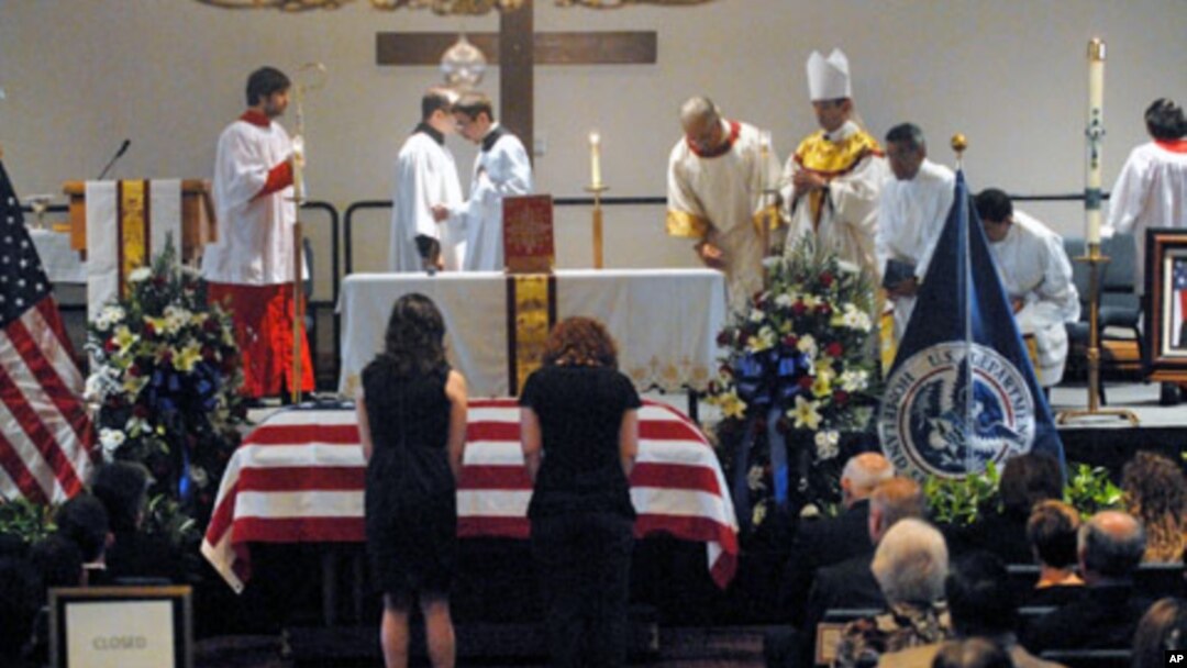 Women bow before the casket of slain U.S. Immigration and Customs Enforcement (ICE) Special Agent Jaime Jorge Zapata during a funeral mass at the Brownsville Events Center in Brownsville, Texas, February 22, 2011