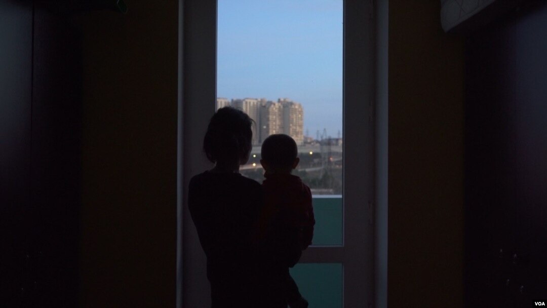A woman holding a child in Baku, Azerbaijan. (Ulviyya Guliyeva/VOA)