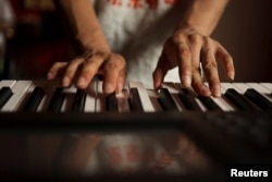 Zu Wenbao, 23, plays keyboard during a practice session with members of the band Star Kids, who like him are all adults with autism spectrum disorder, at a music studio belonging to 38-year-old teacher Chen Shensi, in Beijing, China September 18, 2022. (REUTERS/Tingshu Wang)