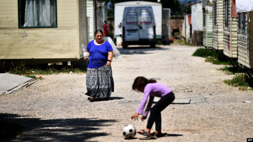 A woman, member of the Roma community, walks at the "River Village" Roma camp, managed by the Onlus Isola Verde association, June 19, 2018, on the outskirts of Rome, Italy.