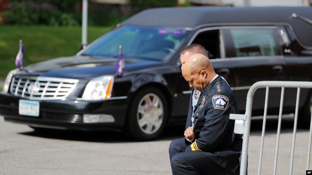 FILE - In this June 4, 2020, file photo, police officers including Minneapolis Police Chief Medaria Arradondo, foreground, take a knee as the body of George Floyd arrives before his memorial services in Minneapolis.