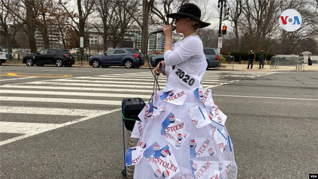 Manifestante viste una falda adornada con papeles que dicen "Robada", en referencia a las denuncias de supuesto fraude electoral de Trump.