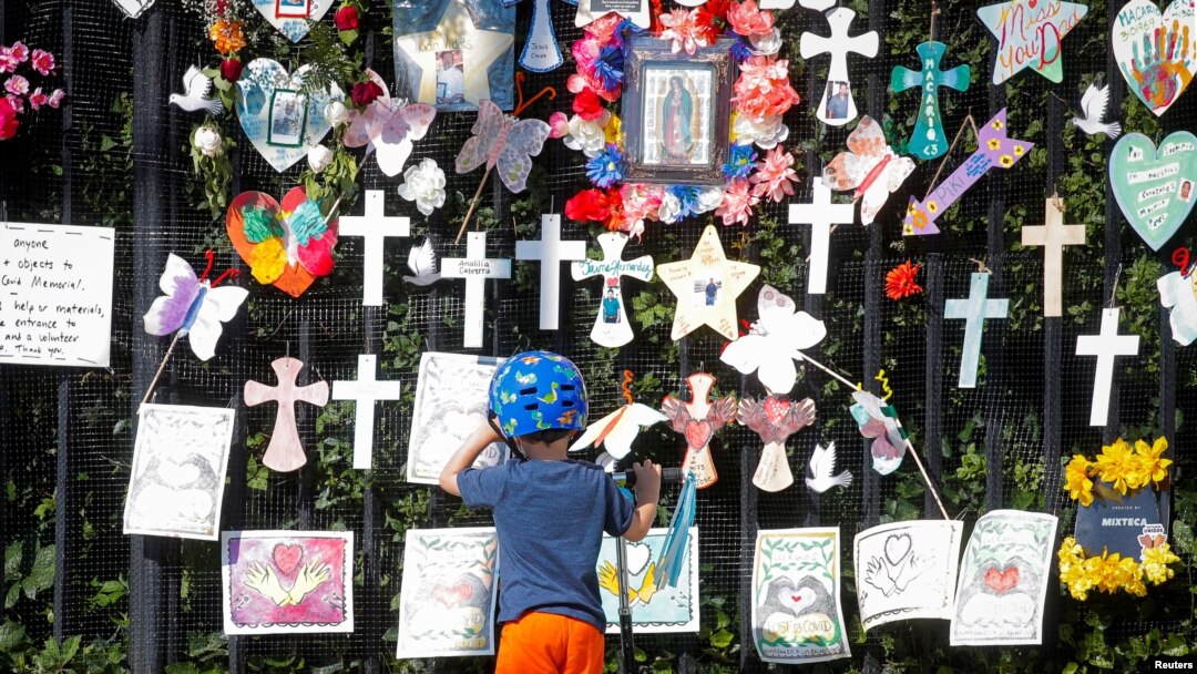 FILE - A child looks at the "Naming the Lost Memorials," at The Green-Wood Cemetery in Brooklyn, New York, June 10, 2021. 