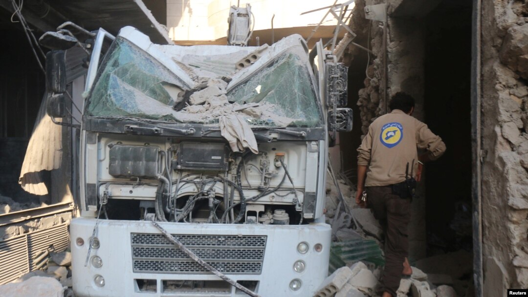 FILE - A civil defense member inspects the damage after the agency's center was hit by an airstrike in a rebel-held area of Aleppo, Syria, Aug. 12, 2016.