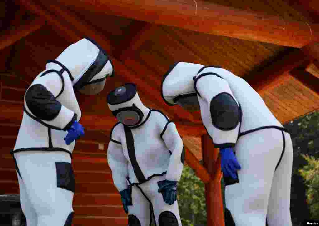 Jake Bodart (L), Austin Johnson (C) and Jessica Rendon (L) of the Oregon Department of Agriculture wear hornet extraction suits during an Asian giant hornet field training day at Birch Bay State Park near Blaine, Washington, Aug. 18, 2021. 