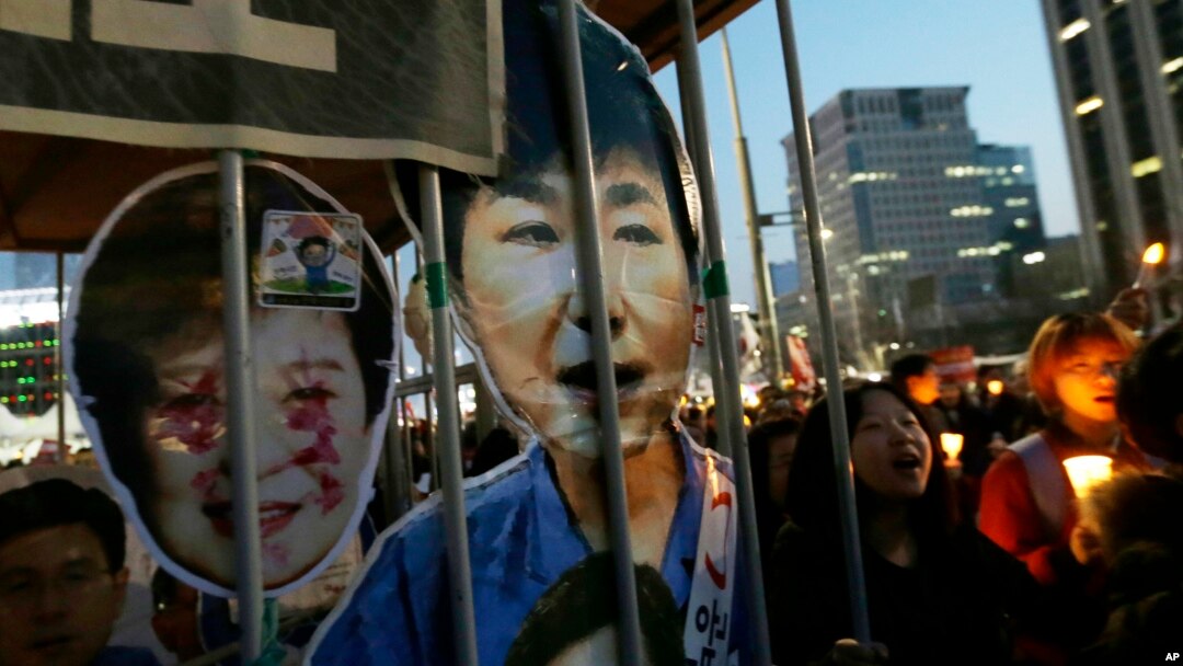 Protesters with portraits of impeached President Park Geun-hye march towards the presidential house during a candle light vigil calling for her arrest in Seoul, South Korea, March 11, 2017.