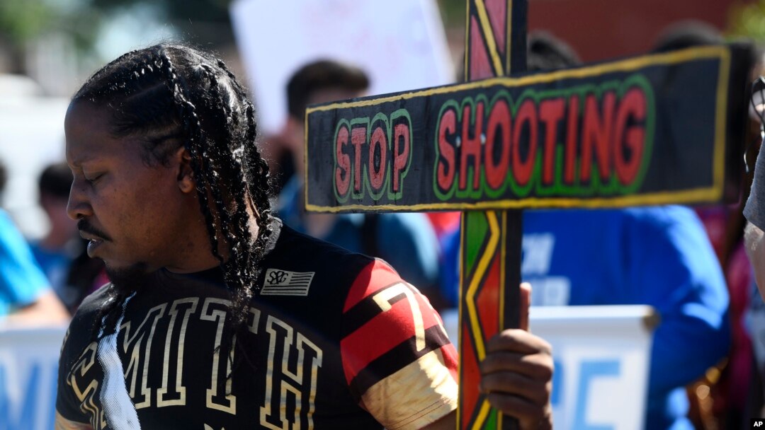 Joseph Saunders carries a cross at a protest July 7, 2018, in Chicago. The protesters were attempting to increase pressure on public officials to address the gun violence that's claimed hundreds of lives in some of the city's poorest neighborhoods. 