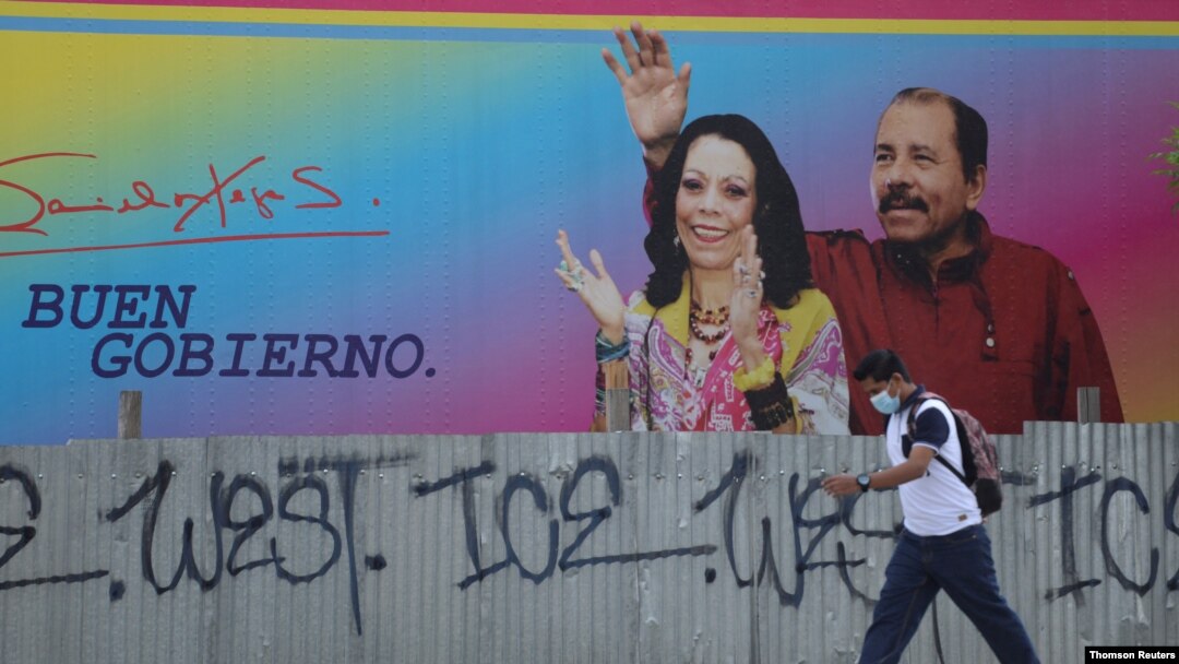 Hombre camina junto a una valla publicitaria que muestra al presidente de Nicaragua, Ortega, y al vicepresidente Murillo, en Managua,
