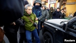 中国警察把一名正在天津法庭外支持维权律师王全璋的支持者抓走塞入警车。（2018年12月26日）