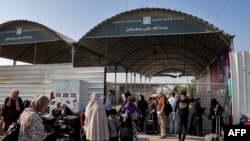 People wait at the Rafah border crossing with Egypt in the southern Gaza Strip on November 1, 2023.