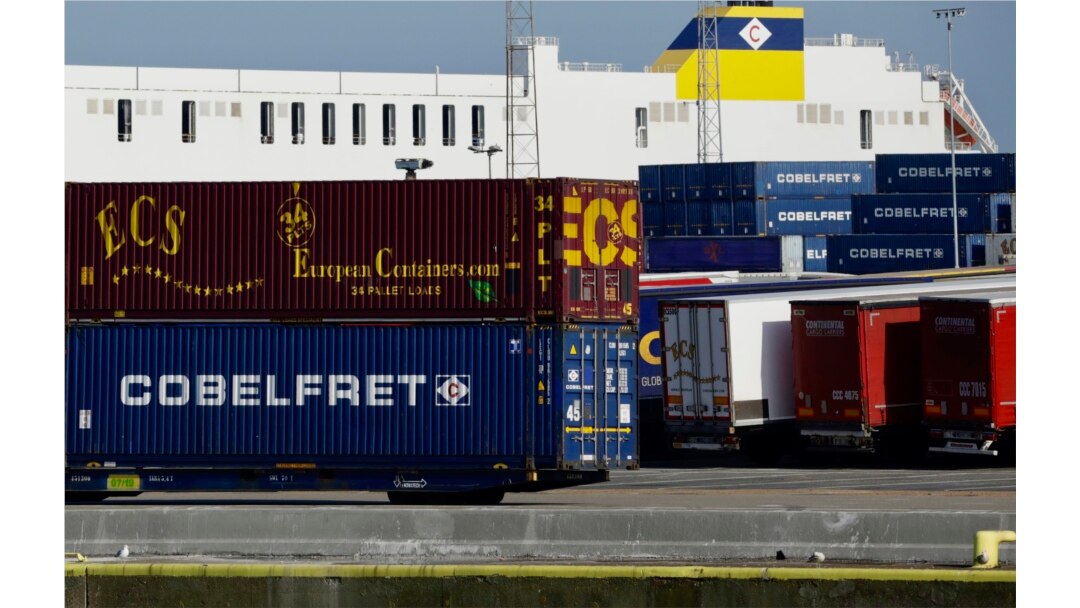 Truck trailers are parked among stacked cargo containers as British police investigate the deaths of 39 people found in a truck container they believe came from Zeebrugge, Belgium, Oct. 24, 2019.