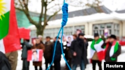 FILE - Iranian exiles shout slogans in front of a mock gallows to protest against executions in Iran during a demonstration outside the Iranian Embassy in Brussels, Dec. 29, 2010.