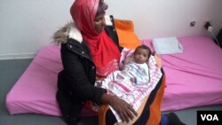 Somali migrant mother Rahma Abukar Ali holds her baby daughter, Sophia, at a refugee center in a small German town near Düsseldorf, where she is awaiting a response to her application for asylum, Oct. 2015. (A. Osman/VOA)