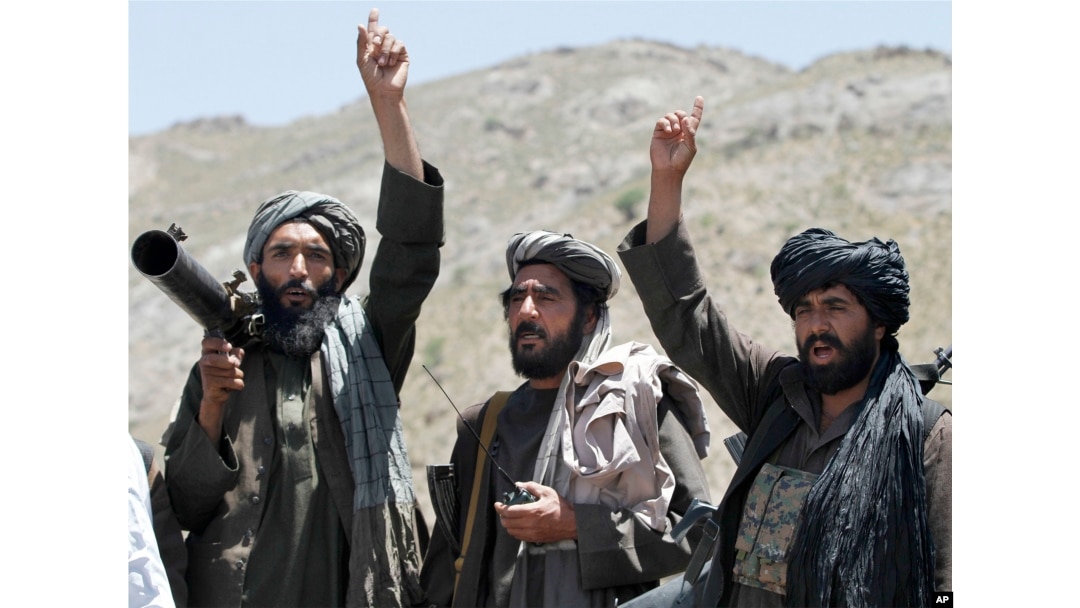 FILE - Taliban fighters react to a speech by their senior leader in the Shindand district of Herat province, Afghanistan, May 27, 2016.
