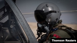 FILE - An Afghan A-29 pilot prepares for flight in the cockpit of his aircraft, at Kandahar Airfield, Afghanistan, Sept. 10, 2017. 