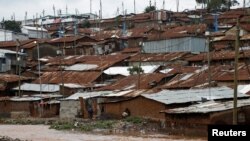 FILE - A man watches a stream from his home in Nairobi's Kibera slum, Kenya, Dec. 3, 2019. 