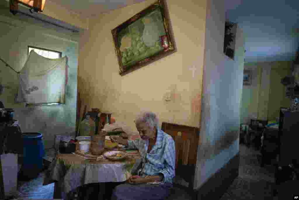Zenobia Ansualve eats lunch at her home in Caracas, Venezuela, Aug. 18, 2021. The 88-year-old Ansualve, who lives alone and has not left her home since the start of the COVID-19 pandemic, said she lives on $20 a month from a room she owns and rents.