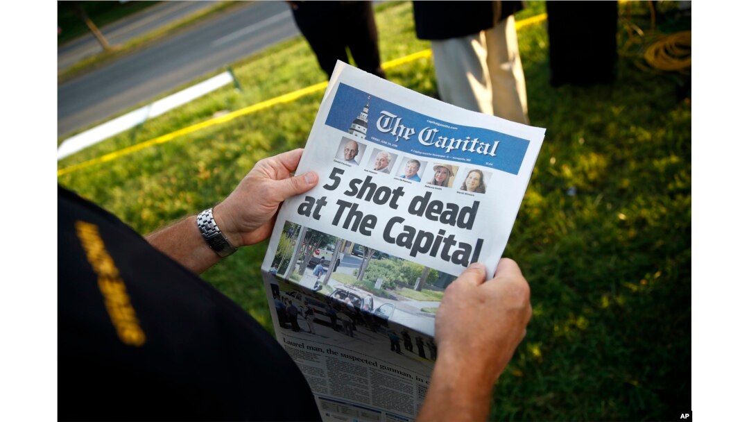 Steve Schuh, county executive of Anne Arundel County, holds a copy of The Capital Gazette near the scene of a shooting at the newspaper's office in Annapolis, Maryland. A man armed with smoke grenades and a shotgun attacked journalists in the building, June 28, 2018.
