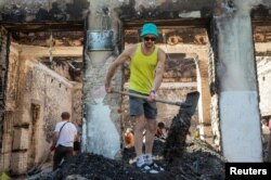 A volunteer cleans up the House of a Culture in the village of Yahidne