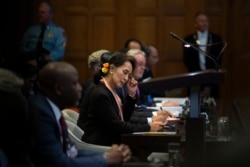 Myanmar's de facto civilian leader Aung San Suu Kyi, center, and Gambia's Justice Minister Aboubacarr Tambadou, left, listen to judges in the court room of the International Court of Justice, in The Hague, Netherlands, Dec. 9, 2019.