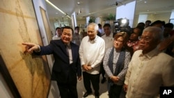 2014年9月11日，在菲律賓舉辦的有關南中國海島嶼主權歷史問題展覽上，菲律賓外交部長羅薩里奧（左二）、司法部長德利馬（右二）和國防部長加斯明（右）在一幅古地圖前聽取最高法院大法官卡皮奧的解說。
