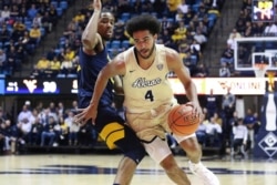 FILE - Akron's Tyler Cheese is defended by West Virginia's Taz Sherman during an NCAA college basketball game in Morgantown, West Virginia, November 8, 2019.