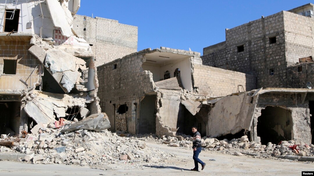 A man walks through damage and debris in Azaz village, north of Aleppo, Syria, March 30, 2014.