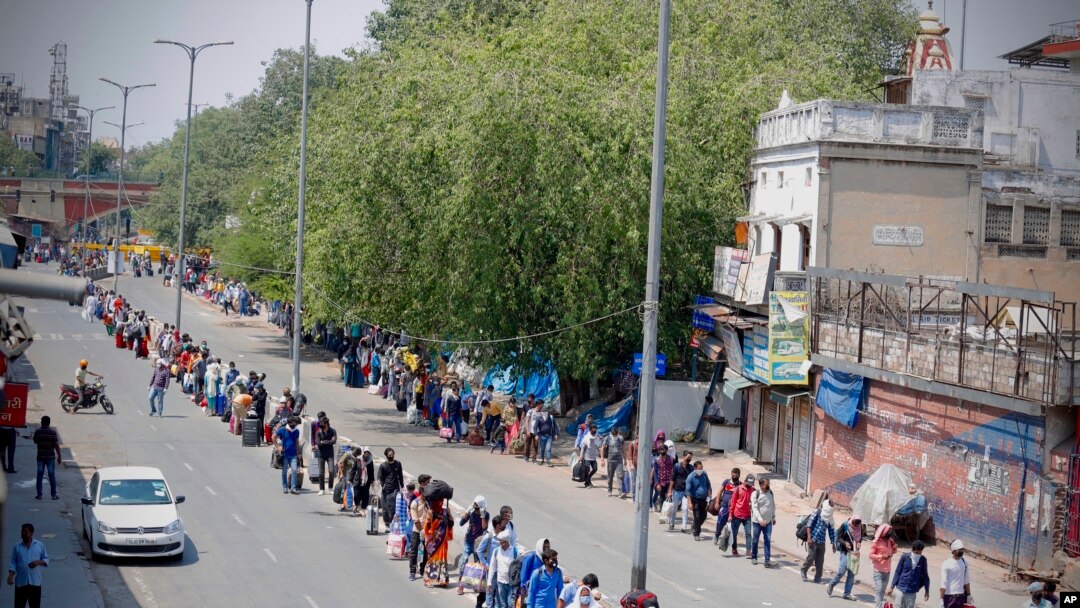 People line up to board trains outside New Delhi railway station in New Delhi, India, May 12, 2020 as India is reopening some of its colossal rail network after seven-week strict lockdown amid an increase in coronavirus infections.
