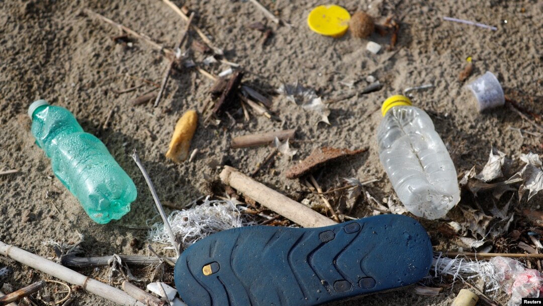 FILE - Plastic bottles and a flip-flop lie on the sand at Maccarese beach in Rome, Italy, Nov. 21, 2018. 