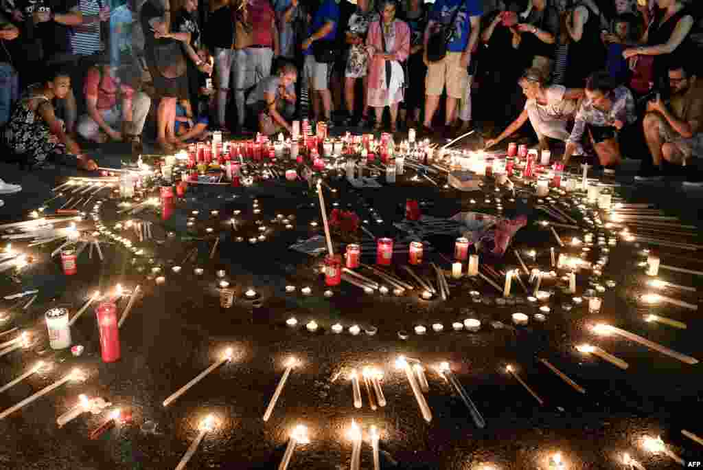 People attend a candlelight vigil in front of the Greek parliament in Athens, July 30, 2018, to commemorate victims of the country's worst-ever wildfires, which have claimed scores of lives.
