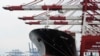 FILE - A cargo ship at China's Tianjin port gets loaded with containers of goods for export. The communist-led country, with 15 years in the World Trade Organization, wants market economy status. Other WTO members aren't sure.