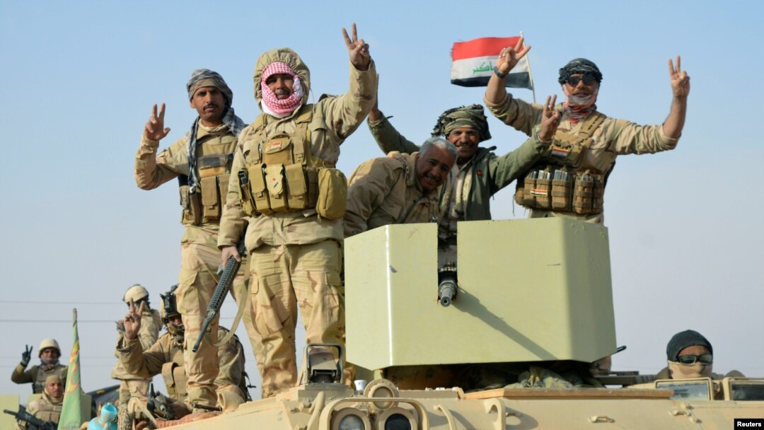 Iraqi forces show victory signs after they captured Rawa town, the last remaining town under Islamic State control, Nov. 17, 2017. 