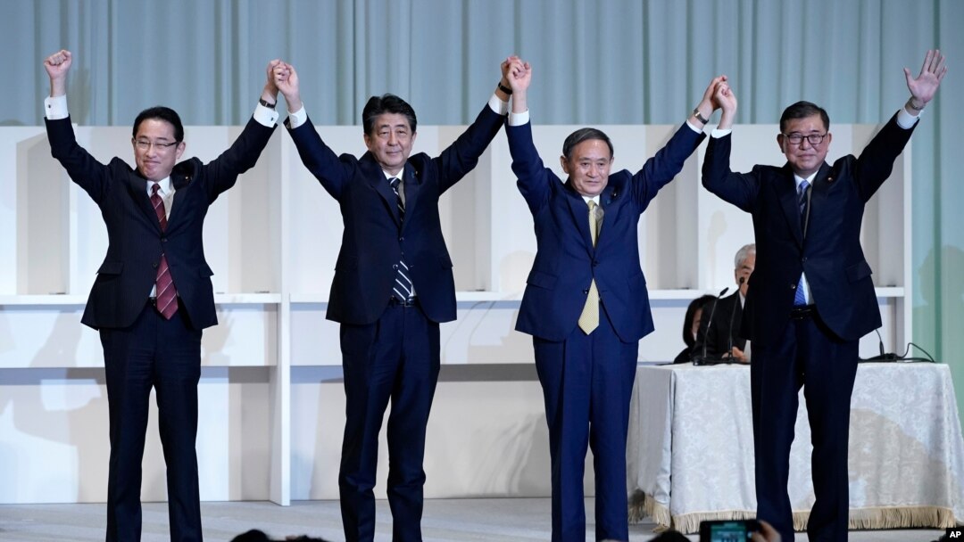 Former Foreign Minister Fumio Kishida, left, Japan's Prime Minister Shinzo Abe, Chief Cabinet Secretary Yoshihide Suga and former Defense Minister Shigeru Ishiba celebrate after Suga was elected as new head of Japan's LDP, Sept. 14, 2020, in Tokyo. 