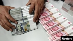 资料照：中国一家银行的雇员在点数美元和人民币。