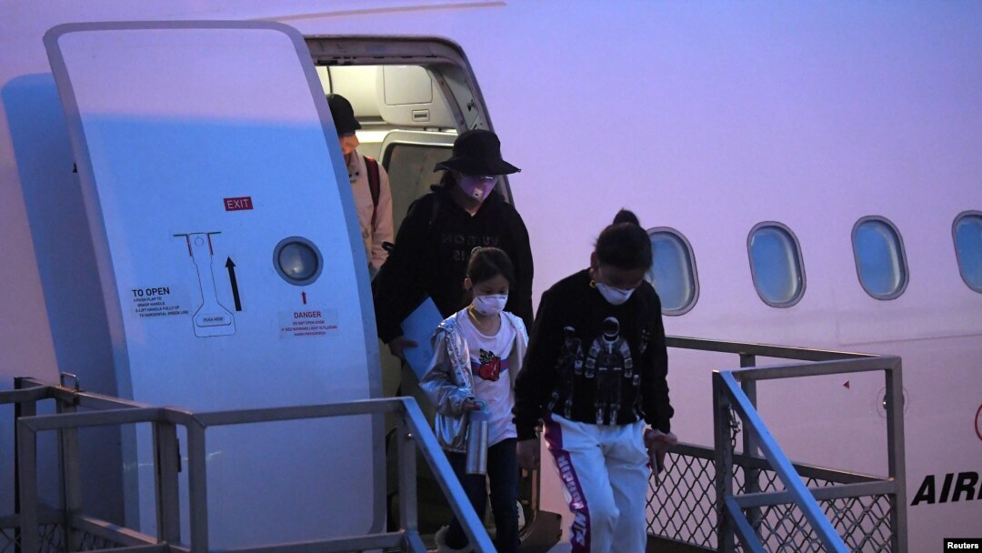 FILE - Australian evacuees who were quarantined on Christmas Island over concerns about the coronavirus disembark from a plane at Sydney Airport in Sydney, Australia, Feb. 17, 2020. 