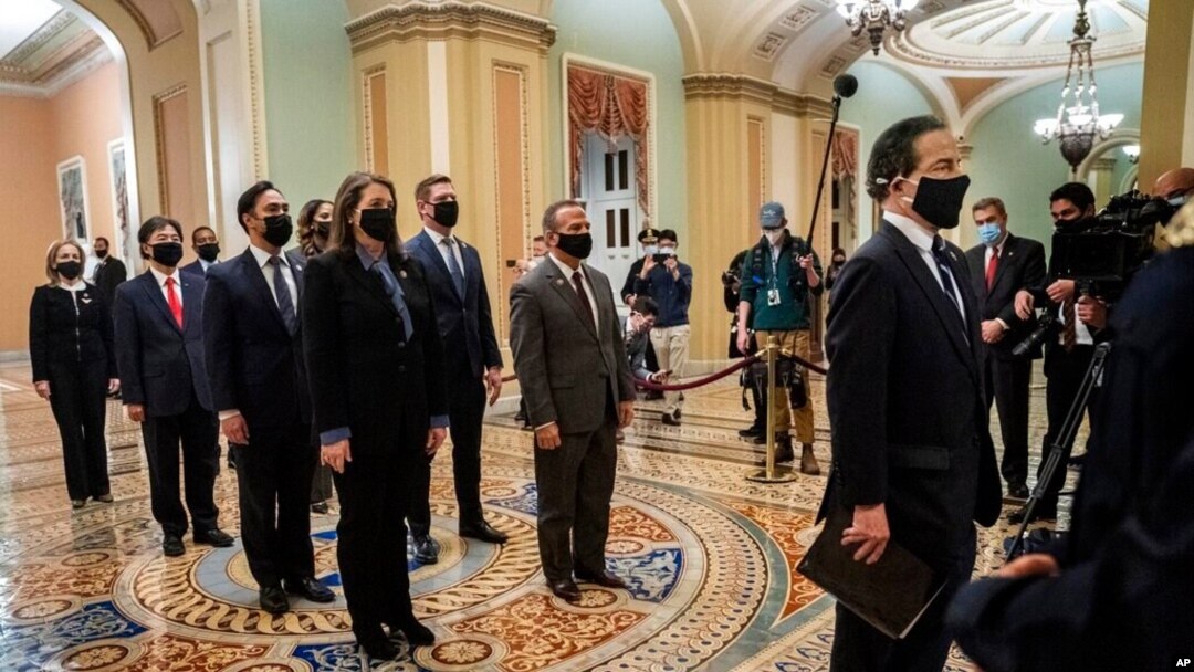FILE - Democratic House impeachment managers stand before entering the Senate Chamber as they deliver to the Senate the article of impeachment alleging incitement of insurrection against former President Donald Trump, in Washington, Jan. 25, 2021.