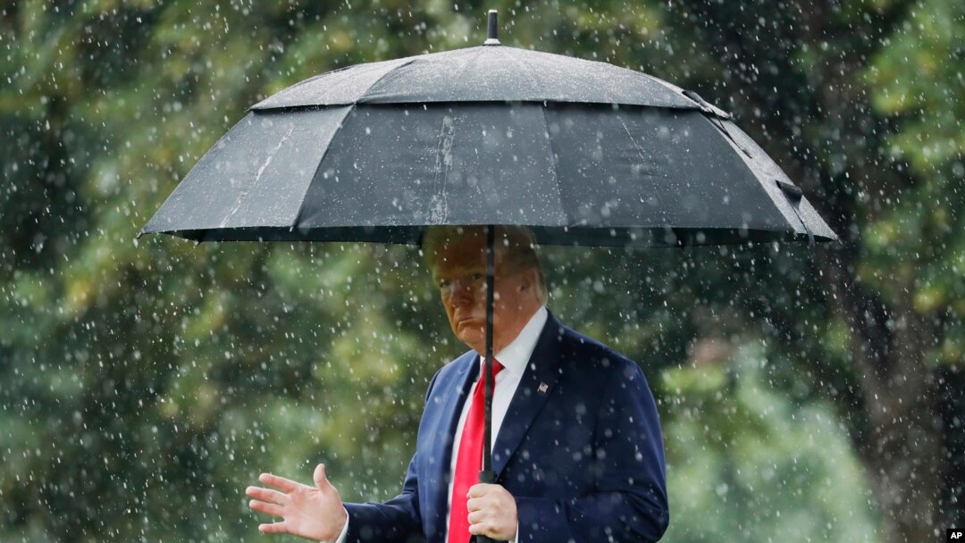 President Donald Trump walks in the rain on the South Lawn of the White House in Washington, June 11, 2020, before boarding Marine One for a short trip to Andrews Air Force Base, Md., and then on to Dallas. 