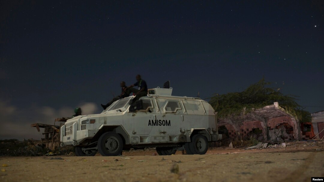 FILE - AMISOM soldiers rest atop armored vehicle during break on street patrol with local police, Mogadishu, Nov. 14, 2013.