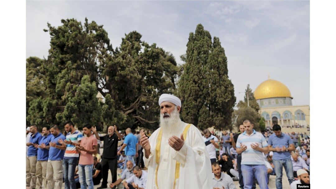 FILE - The Dome of the Rock is seen in the background as Palestinian men take part in Friday prayers on the compound known to Muslims as Noble Sanctuary and to Jews as Temple Mount in Jerusalem's Old City, Oct. 23, 2015.