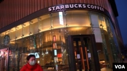 一名戴口罩的女士路過星巴克在北京的一家門店。（2020年2月20日） 