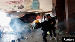 香港理工大學抗議者用雨傘抵擋警察催淚彈 （路透社）
