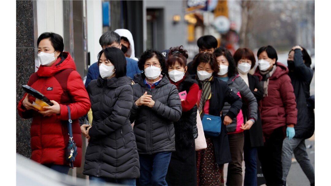People wearing masks stand in a line to buy face masks in front of a drug store amid the rise in confirmed cases of COVID-19 in Daegu, South Korea, March 3, 2020.